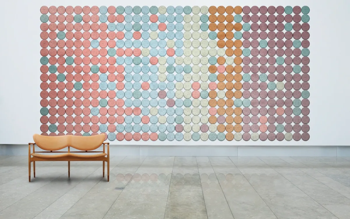Round BAUX wood wool acoustic tiles in several colours on a wall.